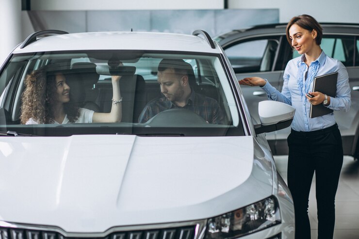 Two person siting on Used car with sales women