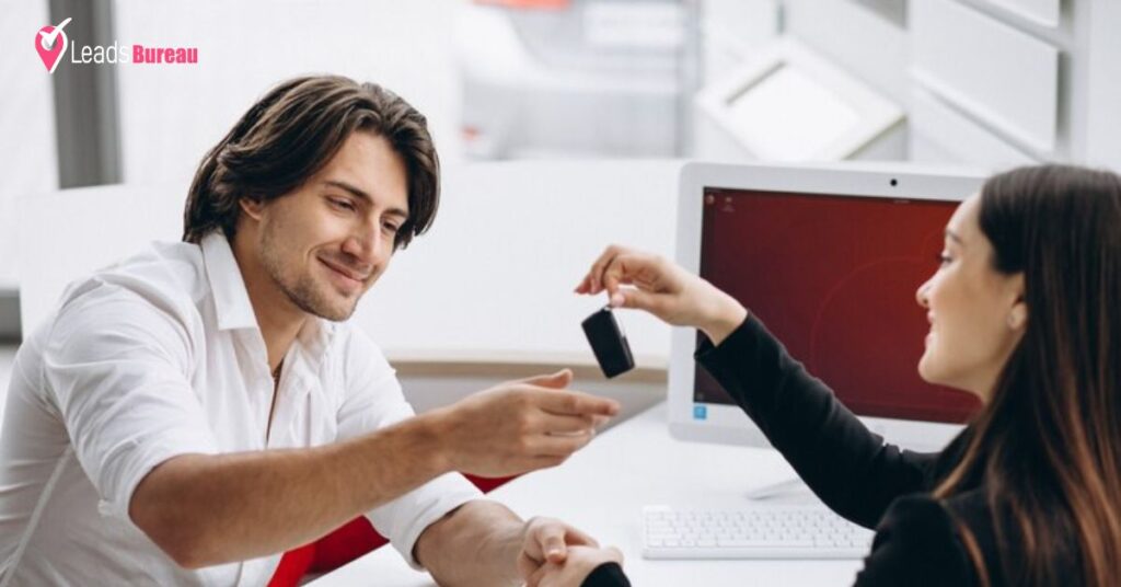 A person takes new car keys with saleswomen